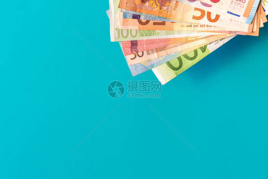 欧元纸币隔离在蓝色背景与柔和的阴影带有复制空间的天蓝色背景角落中的欧元纸币不同价值的欧元现金图片