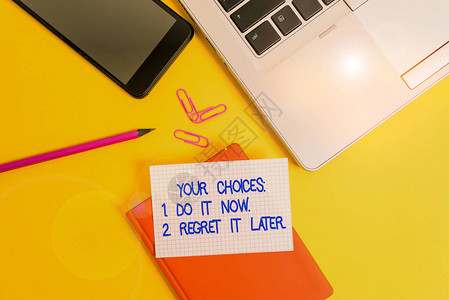 概念手写显示您的选择1现在做2以后悔概念意义在决定笔记本电脑智能手机夹铅笔纸彩色背图片