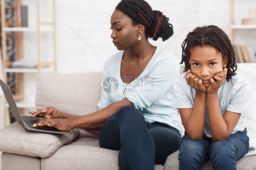 没有时间给孩子非洲妈忙着在家里工作使用笔记本电脑图片