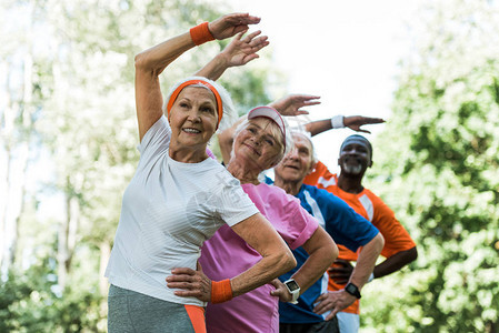 快乐多文化的老年男女在锻炼时用手握图片