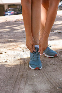 户外运动鞋上系鞋带的女跑步者图片