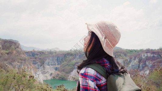 徒步旅行的亚洲背包客女步行到山顶图片