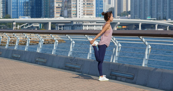 女人在户外跑步前伸腿图片