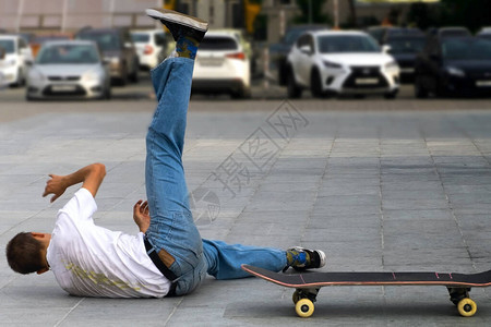 一个滑板员在街上拼命的摔倒图片