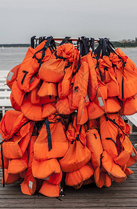 许多橙色的救生衣挂在海边图片