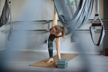 一名年轻女子站在健身房的垫子上练习晨间瑜伽健身瑜伽健图片