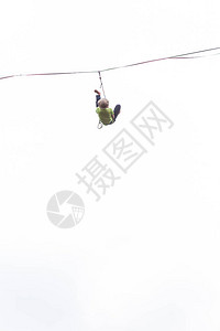 在白色背景上的Highliner反对天空的高线一名男子用拉长的吊索保持平衡赤脚走钢丝的人挂在绳子上克服恐高症背景图片