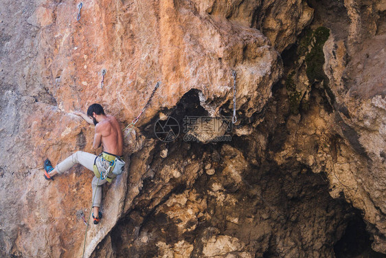 一个强壮的男人爬上悬崖登山者在自然地形上克服困难的攀登路线在土耳其攀岩美图片