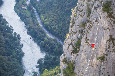山中的高线一个人在伸展的吊索上前进Highline上线了走钢丝的人保持平衡平衡对紧张背景图片