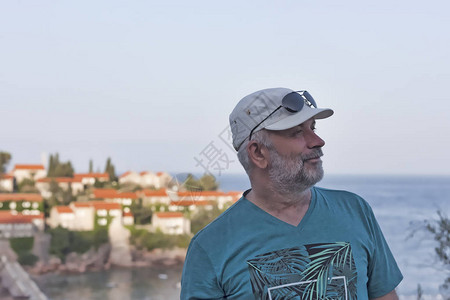 一个身着棒球帽的成熟男子将目视海洋背景和黑山斯维提岛斯维蒂图片