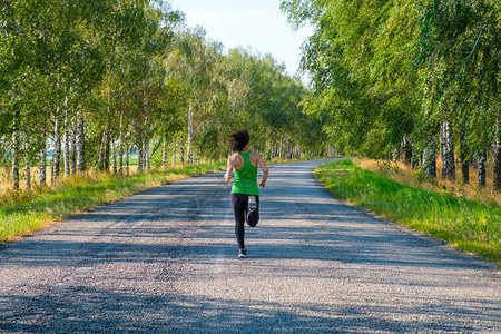 年轻的健身白人女子跑上去转乡间小路图片