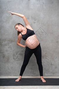 健身房黑色垫子上漂亮孕妇锻炼的肖像工作健身怀图片