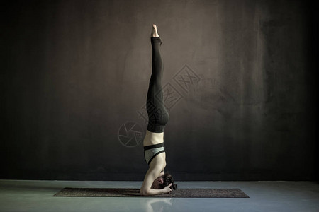 做瑜伽的年轻女子在健身垫上做萨兰图片
