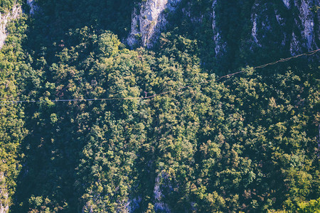 一个人正沿着一条拉长的吊索行走山中的高线人抓住平衡走钢丝者在大自然中的表现Highliner背景图片