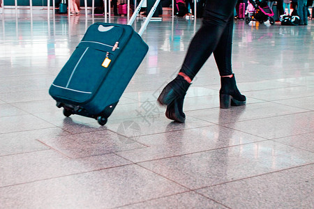 携带行李箱的旅客前往机场办理登记手续并图片