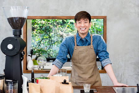 站在咖啡厅柜台的年轻亚洲男子创业者图片