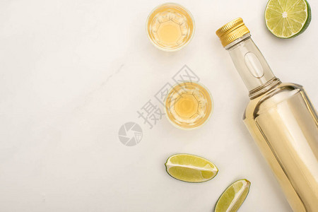 瓶中金龙舌兰酒的顶部视图和白大理石表面带有图片