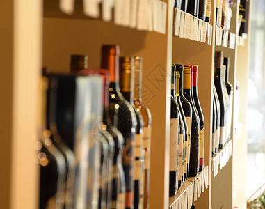 葡萄酒商店木架子上的酒瓶背景图片