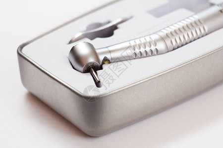 白色背景包装盒中的高速牙科手机用于牙科治疗的牙科器械医疗工具特写图片