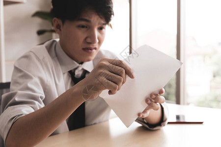 年轻商人在他的办公桌被他读的东西吓得惊呆背景图片