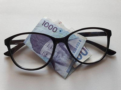 000韩圆钞票和黑色塑料框架眼镜图片