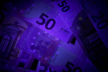 紫外闪光灯束中的钞票背景图片