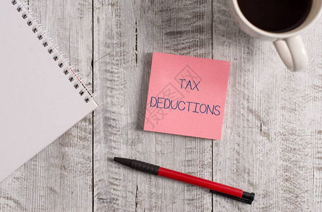 手写文本减税概念照片从某人身上减去的金额或成本是收入固定放置在木桌上方一背景图片
