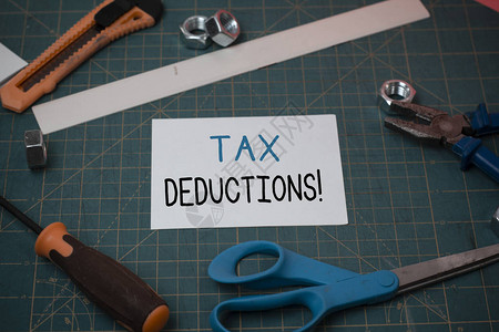 手写文本减税可以对散布在测量垫上的木工设备和普通纸的费用征税的概念图片