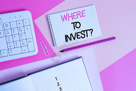 写笔记显示在哪里投资问题询问将资金投入金融计划或股票的商业概念书写设备和计算机材料放置在彩色普通桌子上方图片