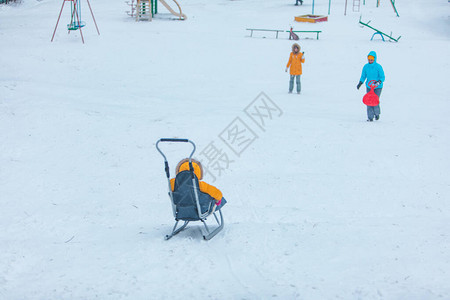 小孩在雪橇上滑下来图片