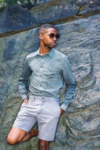 身穿长袖灰色衬衫短裤太阳镜的非裔美国青年男子图片