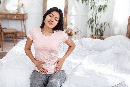 亚洲女童在家中卧床时患上月经癌细胞的胃痛期图片