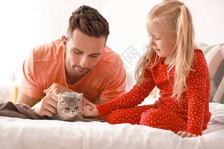 快乐的父亲和女儿与可爱的猫在图片
