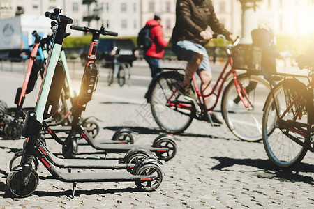 共享电动滑板车停在人行道夏日阳光下使用移动应用出租的背景在欧洲的智慧城市中使用有助于交通交通安背景图片