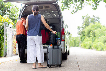 携带行李和司机将行李装进小型公共汽车旅行图片