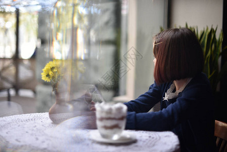 小女孩在咖啡馆里喝热巧克力女学生在咖啡馆里喝可女孩在咖啡馆下课后喝可背景图片