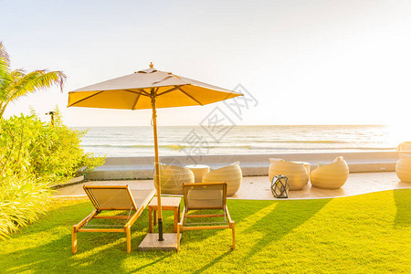 日落或日出时在海边滨周围的保护伞和椅子背景图片