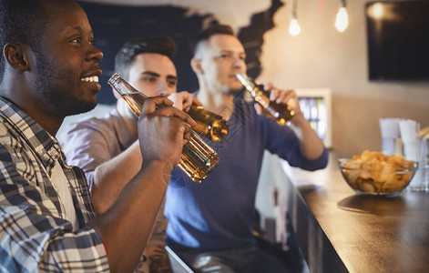 年轻快乐的足球迷在酒吧看球赛喝啤酒全图片