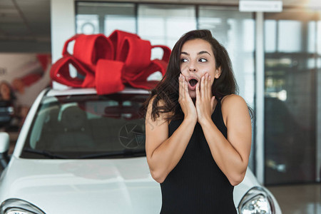 年轻美女在经销中心收买新车感到惊讶在图片