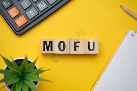 现代营销流行语MOFU漏斗中部带块的木桌上的顶视图图片