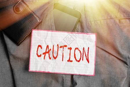 商业照片展示小心避免危险或错误警告标志预防智能手机装置在裤子前袋内图片