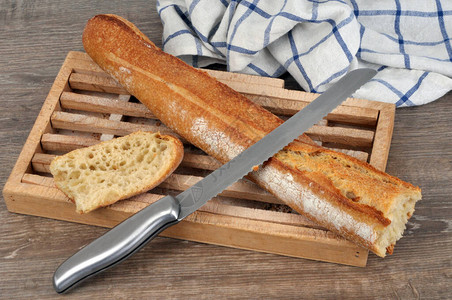 面包板上法式国传统面包袋面带灰背景图片