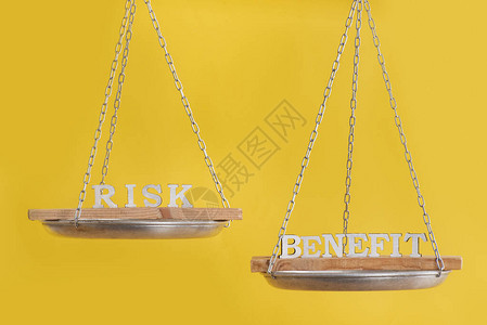 风险与收益的平衡平衡的概念黄色背景上图片