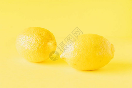 在黄色背景上孤立的柠檬图片