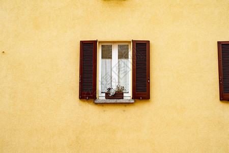 棕色窗户有开着的百叶窗和黄色墙上图片