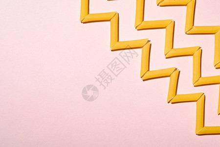 意大利意面粉红背景的原薄粉通心形西格扎模式顶视镜复制空图片