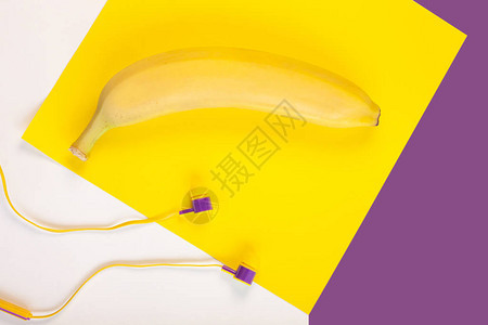黄色平铺香蕉水果和耳机在白色背景复制空间背景图片