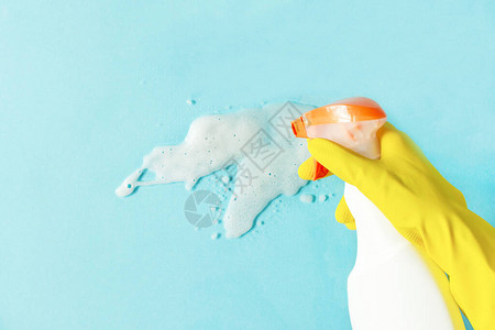 手拿黄色橡皮手套清洁玻璃和洗涤剂清洁用图片