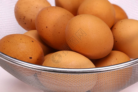 铝筛中的棕色鸡蛋图片