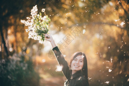 梦中情人的美丽女孩在bokeh背景白毛衣上黄色叶子图片